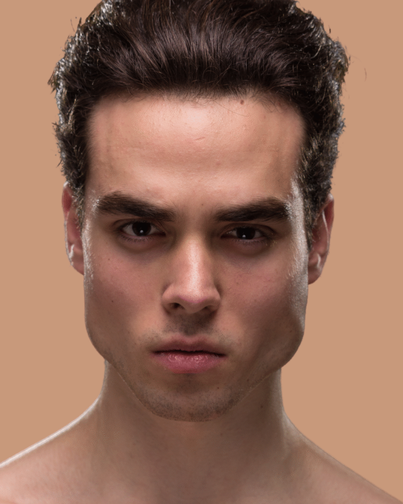 Young man with defined jawline and sculpted facial features, showcasing a natural and youthful appearance, relevant to aesthetic treatments like Youthful Contour.